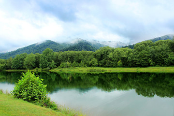 Landscape with a lake, forest and mountains. Wild nature.