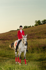 The horsewoman on a red horse. Horse riding. Horse racing. Rider on a horse.