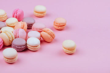 Different types of macaroons on pink background.