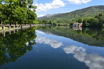 Fototapeta na wymiar Lake Called The Sea With A House On The Other Side Of The Shore And The Clouds Reflected In The Water In The Gardens Of The Farm. Art History Biology. June 19, 2018. La Granja Segovia Spain.