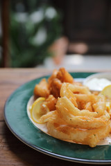 Fish and chips fried fish and potatoes on wood background vintage style