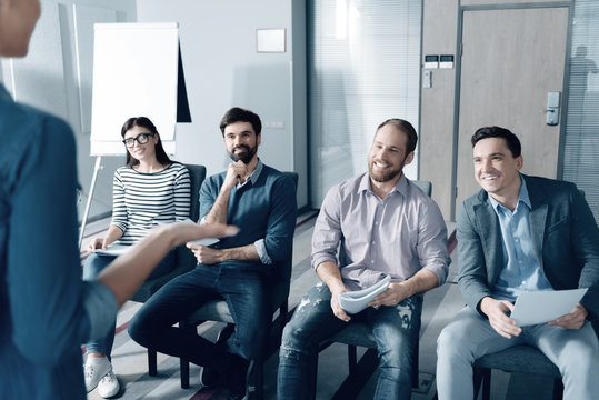 Ready to work. Cheerful enthusiastic colleagues sitting in the office and listening to their chef while working in the office with pleasure