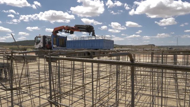 CAMIÓN PLUMA CON  FORJADOS EN LA CONSTRUCCIÓN DE UN EDIFICIO INDUSTRIAL