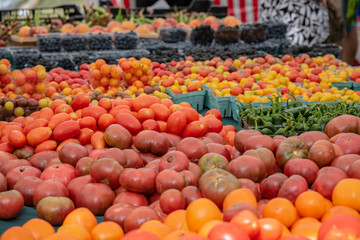 Many fresh tomatoes and other fruits together in a farmer market