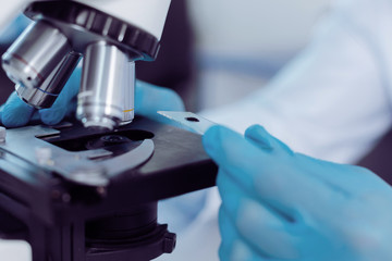 Biological analysis. Close up of a microscope slide with a test sample on it while being ready for...