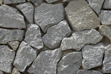 A rough wall of granite cobblestones of different shapes and sizes. Original design background