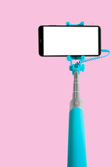 Monopod for selfie with smart phone. Selfie stick with smartphone isolated on pink background