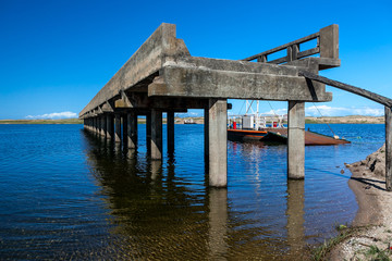 Old pier with ferry behind it