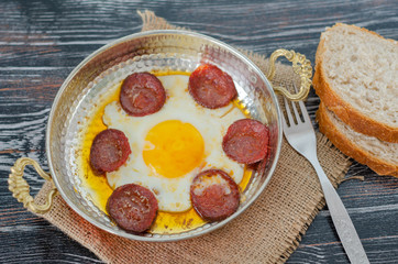 Sausage with egg in copper pan turkish meal