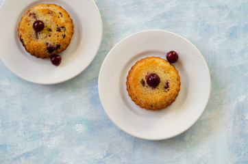 Fresh sponge cakes with cherries on rustic wooden background