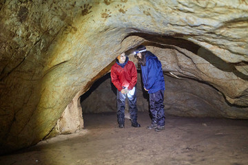 Couple of hikers exploring a cave