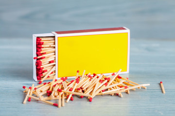 Matchstick out of matchbox on color wood table.