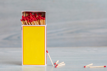 Matchstick out of matchbox on color wood table.