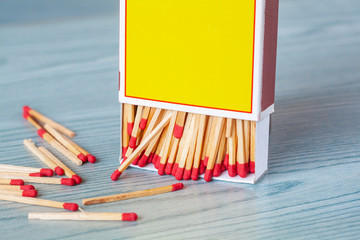Matchstick out of matchbox on color wood table.