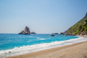 Fototapeta na wymiar Sand, wild beach coast with sea or ocean and mountain rocks 