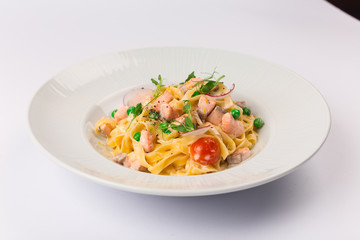 Front and top view isolated - Tagliatelle with salmon and tomatoes. 