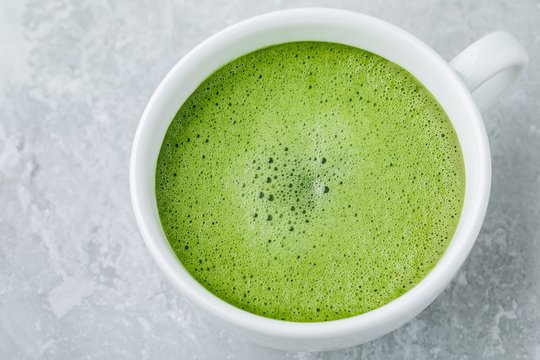 Japanese green tea latte in white cup on gray background