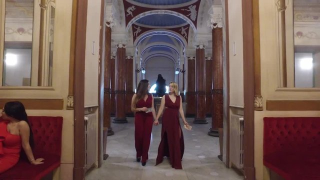 4K beautfiul girls walking into opera theatre with couple in the background