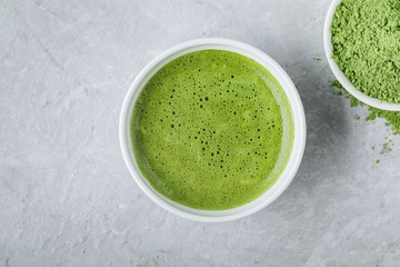 Japanese matcha green tea latte in white bowl on gray background © NBLX