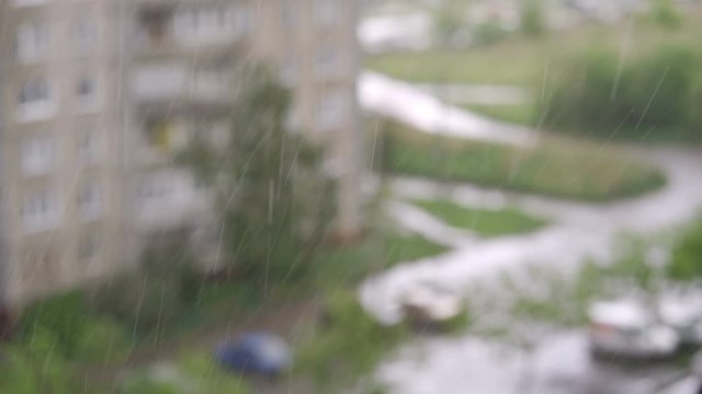 Heavy rain falling against large window pane
