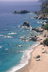 Sand, wild beach coast with sea or ocean and mountain rocks