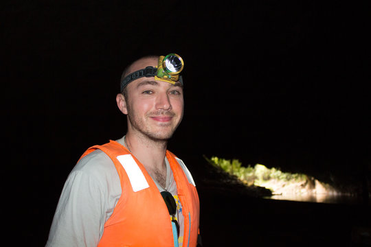 A Young Man With A Headlamp In The Cave
