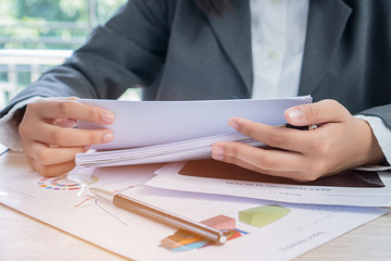 Hands young female business managers checking and arranging stack of unfinished documents reports papers for result graph marketing, new startup project for plans job succes in Busy office