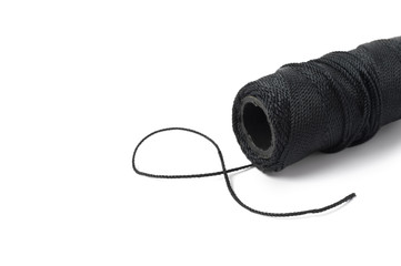 Spool of black string on white background
