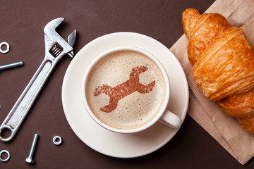 Cup of coffee with  wrench on the foam. I like a coffee break with  croissant. Repair service concept. Technical support