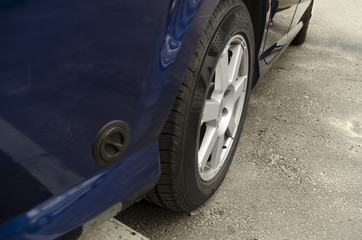 Close up view with automobile. Front car wheel on the asphalt road. Tyre, tire.