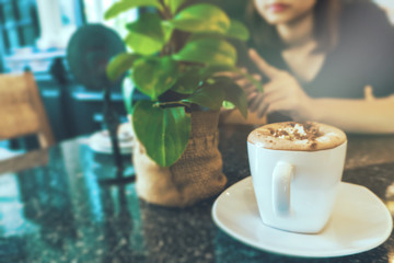 Women are using a smartphone with a cup of coffee in the store. Side view