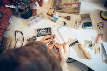 Different goldsmiths tools on the jewelry workplace. Jeweler at work in jewelry.