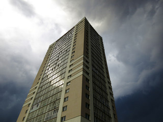 The beginning of a thunderstorm over a skyscraper.