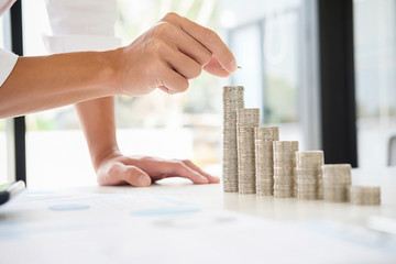 Rows of coins for finance and banking concept with business man and woman.hand putting money coin stack growing business