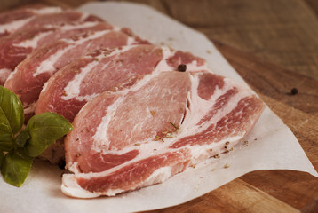 Raw pork meat with spices, wooden cutting board. Food Cooking Ingredient. Top view with copyspace.