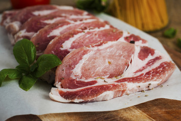 Raw pork meat with spices, wooden cutting board. Food Cooking Ingredient. Top view with copyspace.