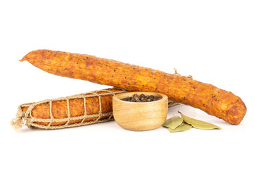 Group of two whole dry smoked ham sausage black pepper in a wooden bowl and bay laurel leaves isolated on white
