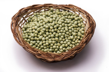 Green peas in cane basket isolated on white background