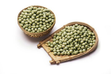 Green peas in cane basket isolated on white background