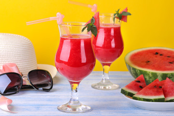 Watermelon smoothies with ripe fresh watermelon and summer accessories on a bright yellow background