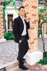 Young stylish handsome man posing in modern city park