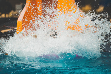 splashings from girl gone down on the rubber ring by the orange slide in the aqua park. Summer...