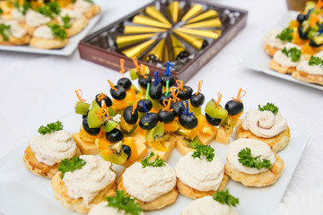 Snacks, fruits and drinks on table, outdoors. Garden party concept