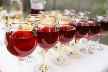 A lot of glasses of red wine in a row on the bar stand side view