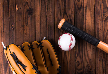 Top view of baseball bat, ball and glove wooden table. 