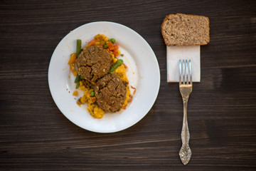 photo of a real meal on a dark background on a white plate.
