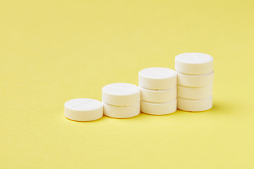 Pills in stacks on the yellow background