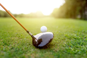 Gordijnen Golf club driver and golf ball on the grass field at tee off © tosspra