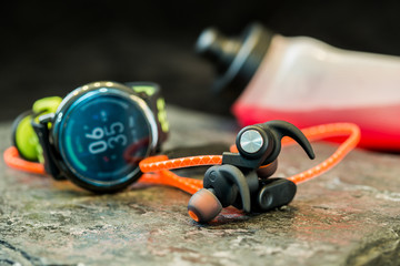 Obraz premium Headphones and sport equipment on dark background