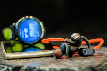 Obraz premium Headphones and sport equipment on dark background